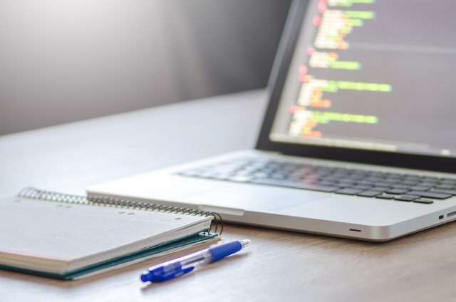 A laptop and a pen represent the digital workspace setting.