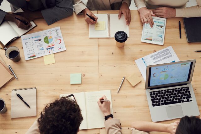 People sit at the desk discussing the top trends for sales and marketing leaders.