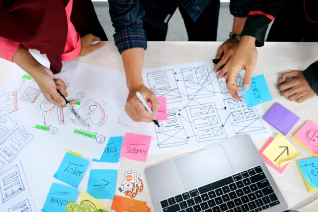 A team of employees work on the papers to understand the perfect customer experience journey.