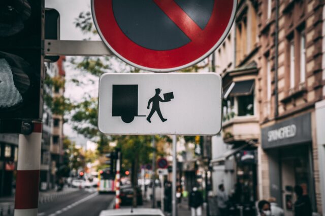 A street sign shows a mailman delivering fast service for better CX.