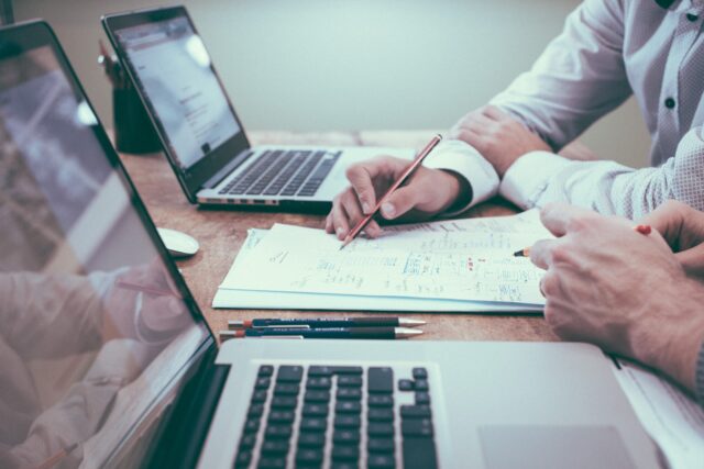 Two hands work on the latest research about the post-pandemic customer experience.