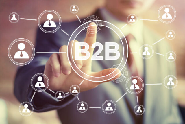 A man pointing his finger on the screen with B2B written on it.