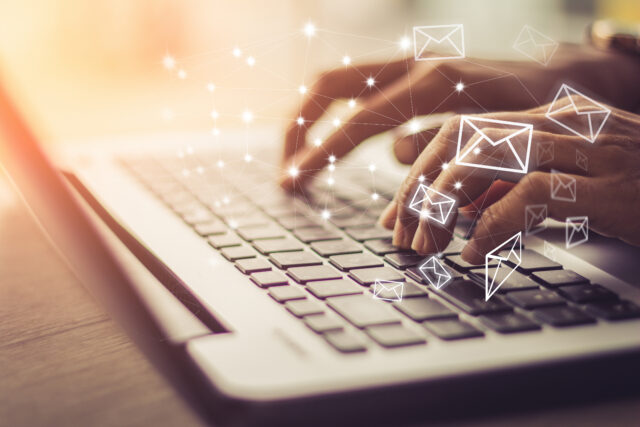 Hands typing emails through the Email Service Provider on the laptop keyboard.