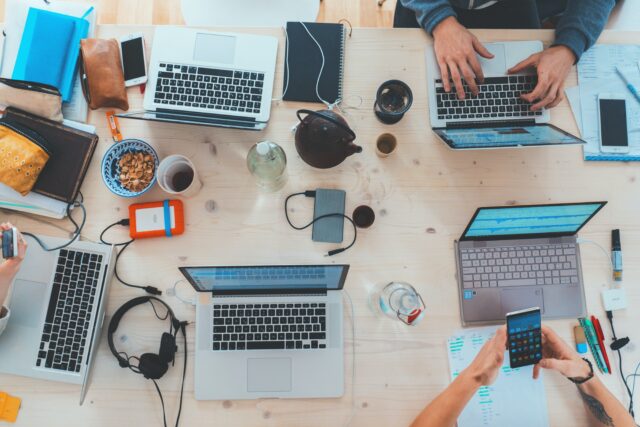 a working table full of computers illustrating digital transformation programmes