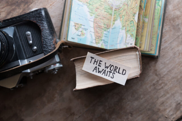 A paper on a world map says the world awaits the travel industry recovery.