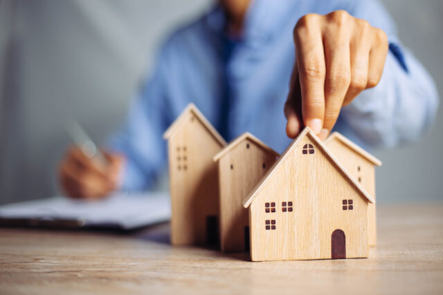A small wooden building represents the customer experience in real estate.