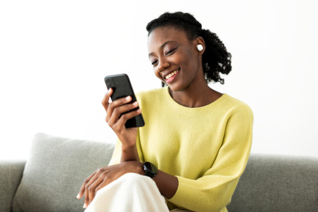 A woman uses her phone to go through the digital customer journey.