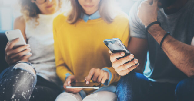 an image showing a group of people buying via mobile phone