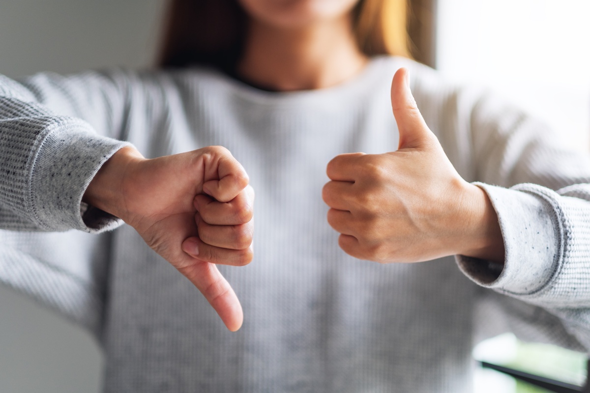 Woman showing the sign of yes and no with her hands.